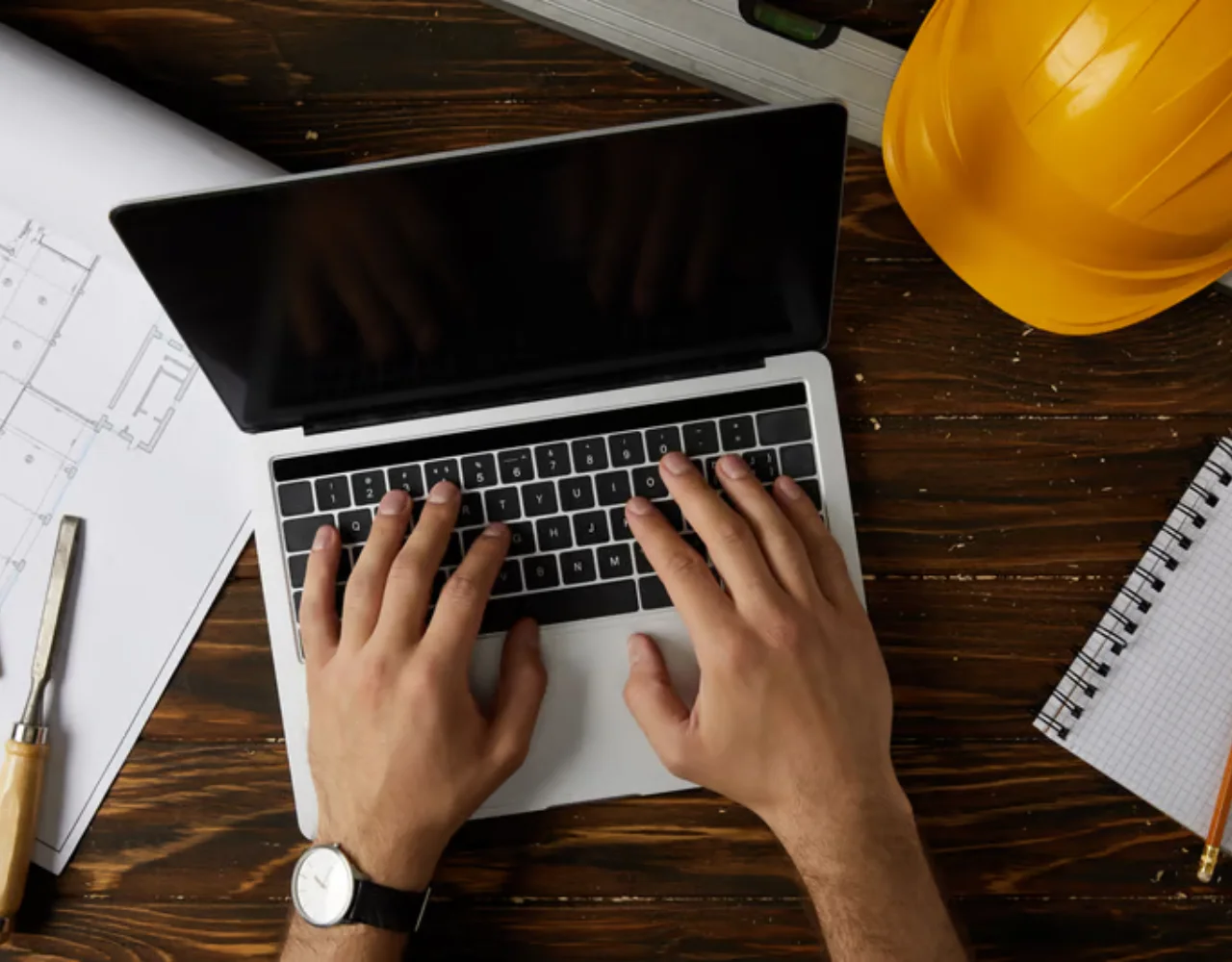 Construction digital marketing planning with laptop, plans and hard hat